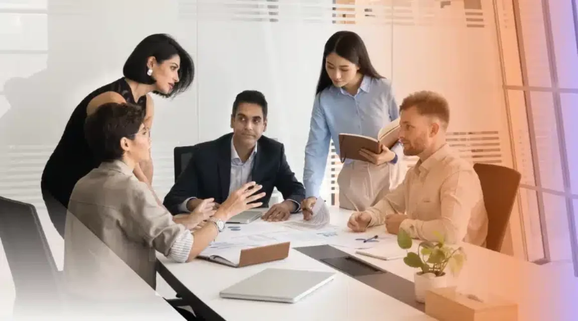 A sales team reviewing performance data and reports together in a modern office.